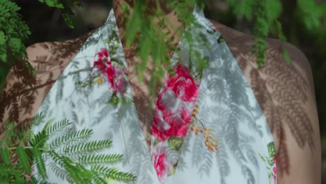 primer plano descendente de una niña en un parque con un vestido de flores que fluye