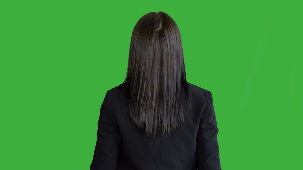 молодые привлекательные брюнетки, стоящие в изоляции на зеленом фоне экрана. портрет красивой профессиональной женщины в костюме