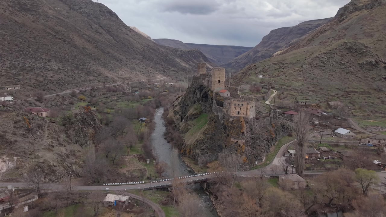 Vista panorámica aérea de la Fortaleza de Khertvisi rodeada por un escarpado paisaje georgiano, un valle fluvial y un dramático paisaje montañoso