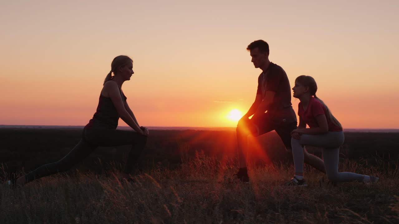 familia con un niño haciendo ejercicios juntos en un lugar pintoresco al atardecer