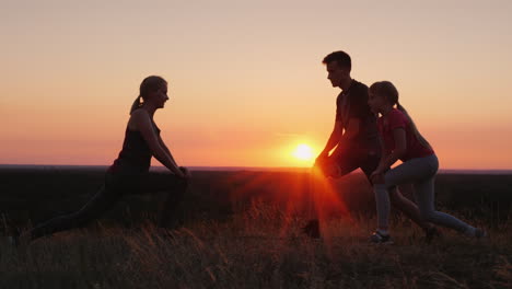 familia con un niño haciendo ejercicios juntos en un lugar pintoresco al atardecer
