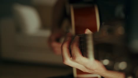 close up shot of the hands of a guitarist moving amongst the frets