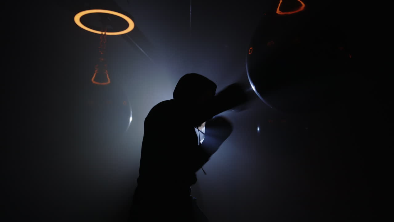 Silhouette of boxer in dark gym