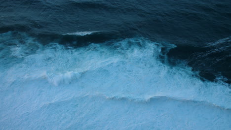 aerial view of powerful ocean waves crashing on the shore