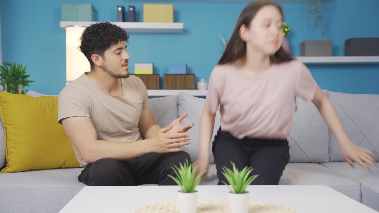 불행하고 압도된 젊은 부부가 다투고 있습니다.