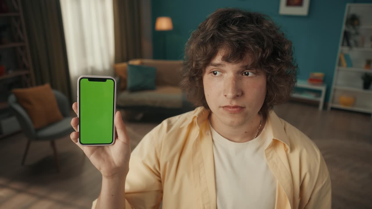 Young Person Holding Smartphone with Green Screen