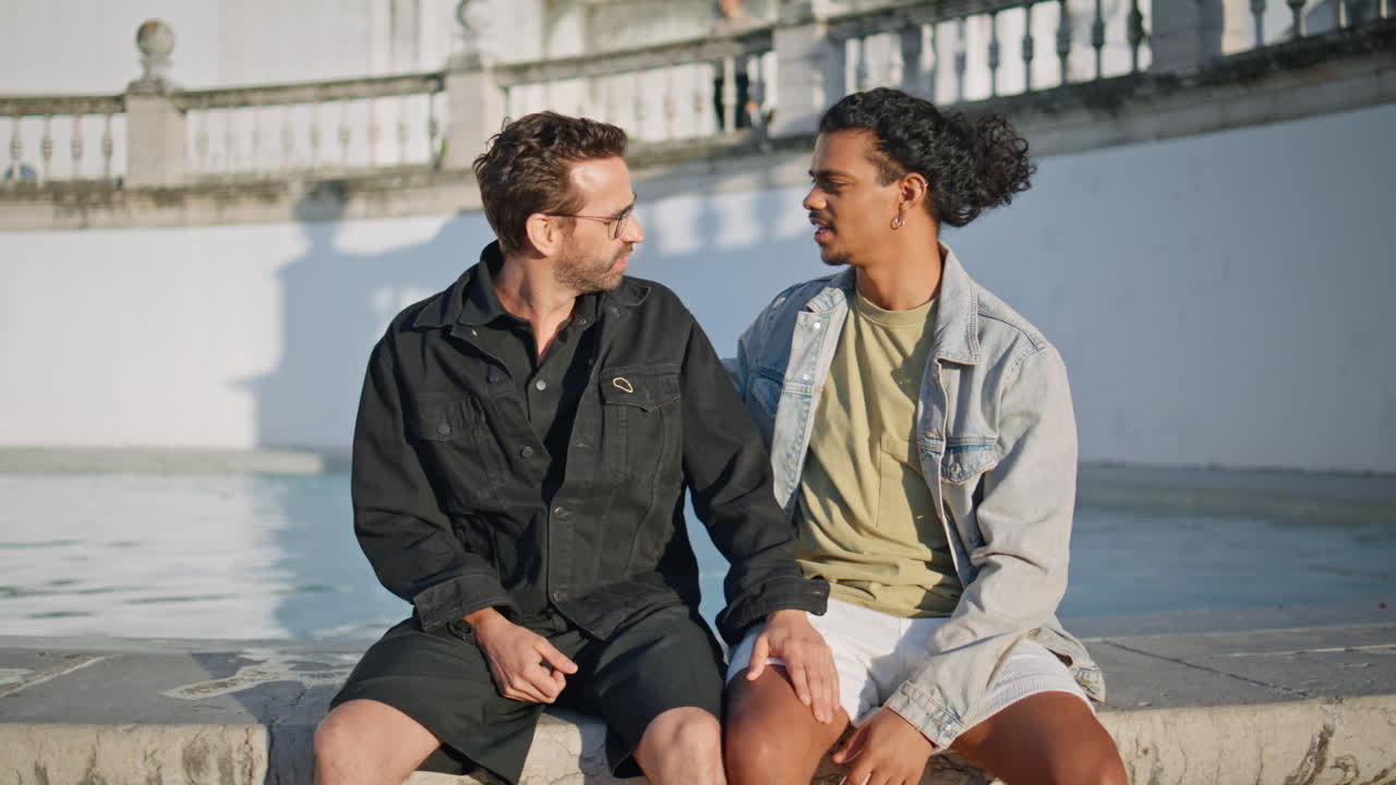 dos hombres hablando junto a una fuente