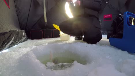 ice fisherman fishing in tent