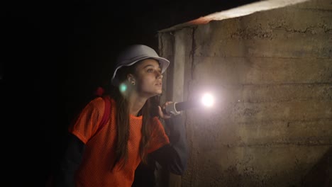 adolescente explorando un túnel oscuro con una linterna