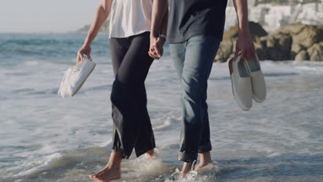 smiling young couple walking through water