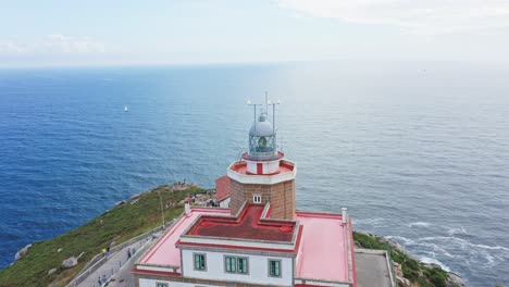 finisterre lighthouse on rocky cliff by the atlantic ocean, pilgrimage point, end of the old world