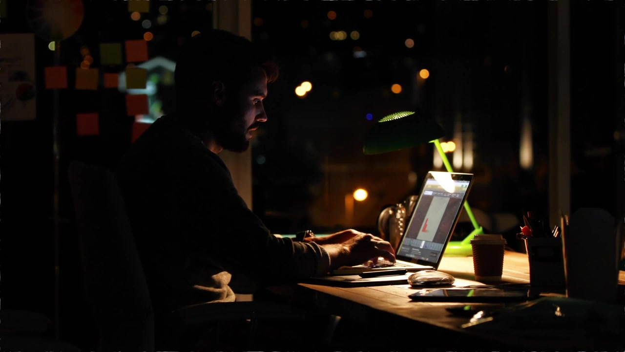 Lampadine Edison vintage e uomo che lavora al laptop di notte