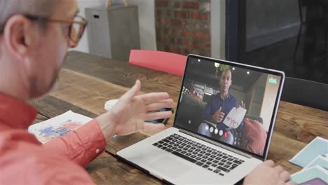 hombre de negocios caucásico en una videollamada con un colega caucásico en la pantalla