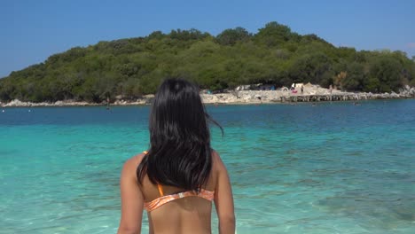 happy and carefree young tourist in bikini at beach running towards camera