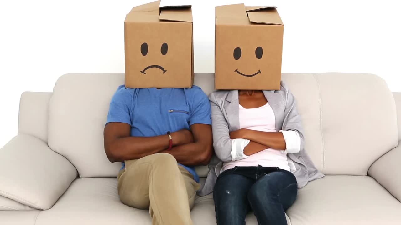 parejas sentadas en el sofá con cajas de emoticones en sus cabezas
