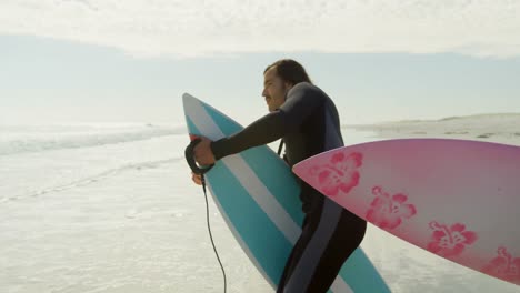 couple with surfboard standing on the beach 4k