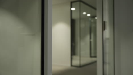 Modern-glass-office-door-slowly-closing-secure-in-empty-business-interior