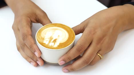 Frauen-Halten-Eine-Kaffeetasse-Auf-Dem-Tisch,