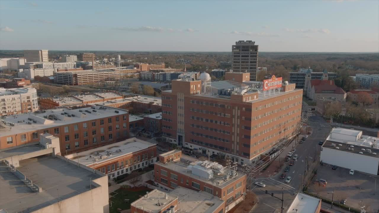Aerial panoramic view of Durham city with American flag waving in the wind on building rooftop, North Carolina. USA