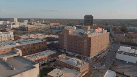 aerial panoramic view of durham city with american flag waving in the wind on building rooftop, north carolina. usa