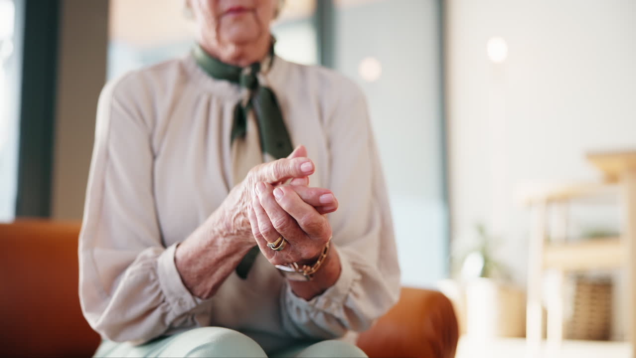 Elderly woman massaging her hands to relieve arthritis