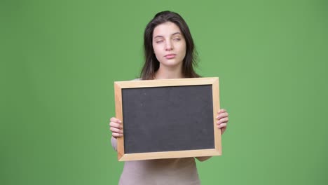 young beautiful woman thinking while holding blackboard