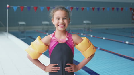 portrait of girl standing by edge of swimming pool ready for lesson