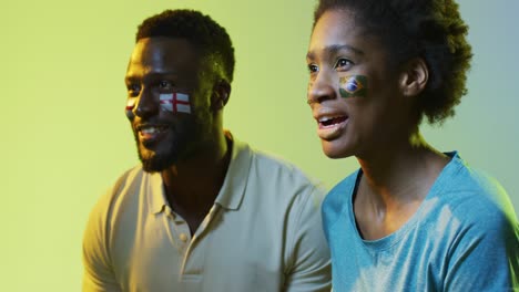video de alegres aficionados al deporte afroamericanos con banderas de inglaterra y portugal