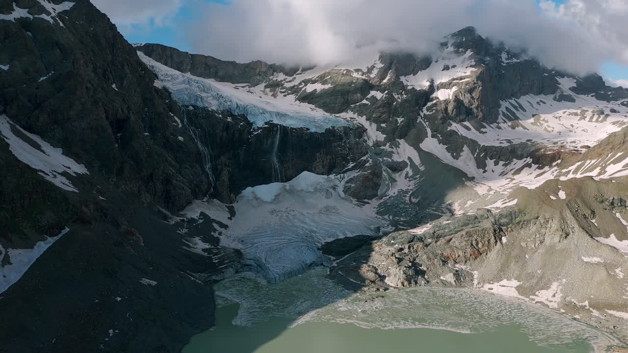 nubes sobre montañas escarpadas en el glaciar fellaria en valmalenco, alpes reatianas centrales, italia