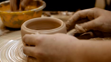 potter is making clay pot on the potter's wheel