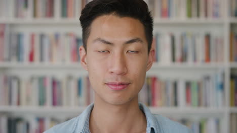 portrait-intelligent-young-asian-man-student-looking-handsome-teenage-male-in-library-bookshelf-background-slow-motion