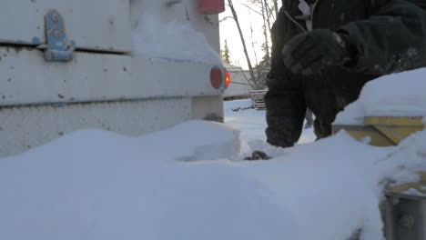 一名男子在雪地卡车后面撞下链条的慢动作镜头