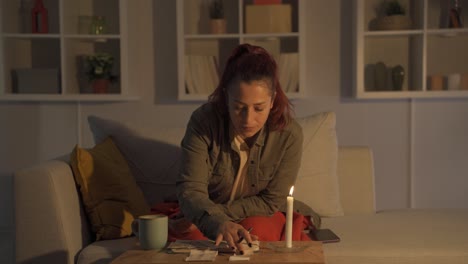 mujer con cuenta en casa a la luz de las velas.