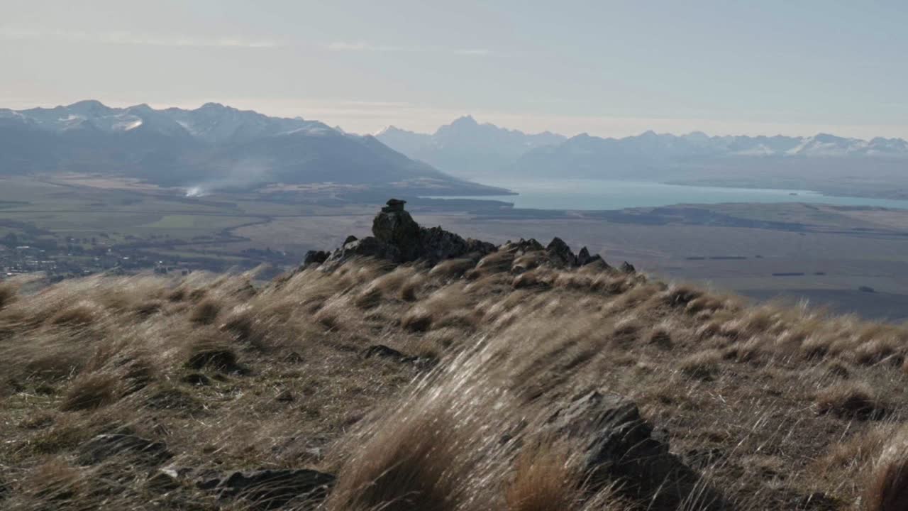 Strong winds whipping dry tussock grass on mountain top