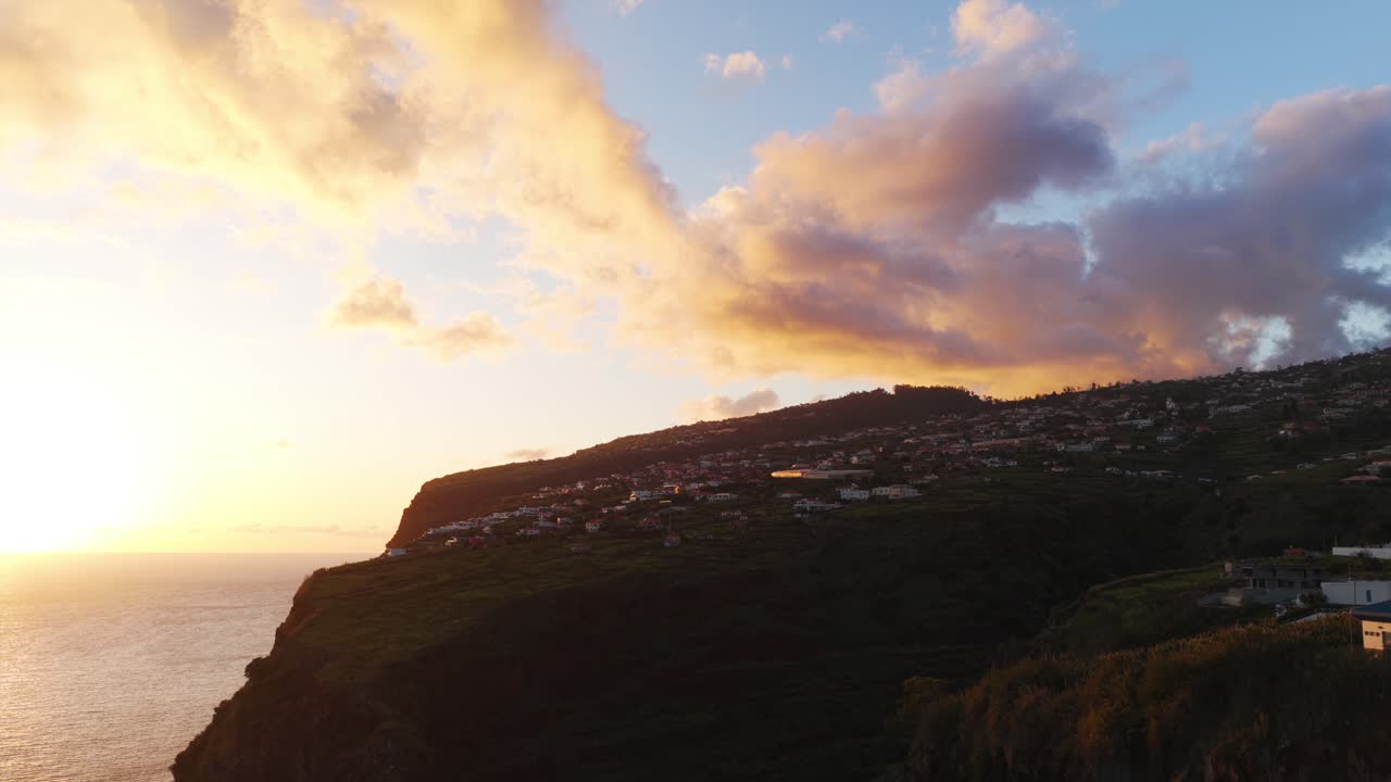 Aerial view of Calheta's coastline at sunset with vibrant sky