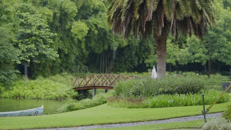 a charming pedestrian bridge arches over a small pond in antigua, guatemala, with rain gently falling