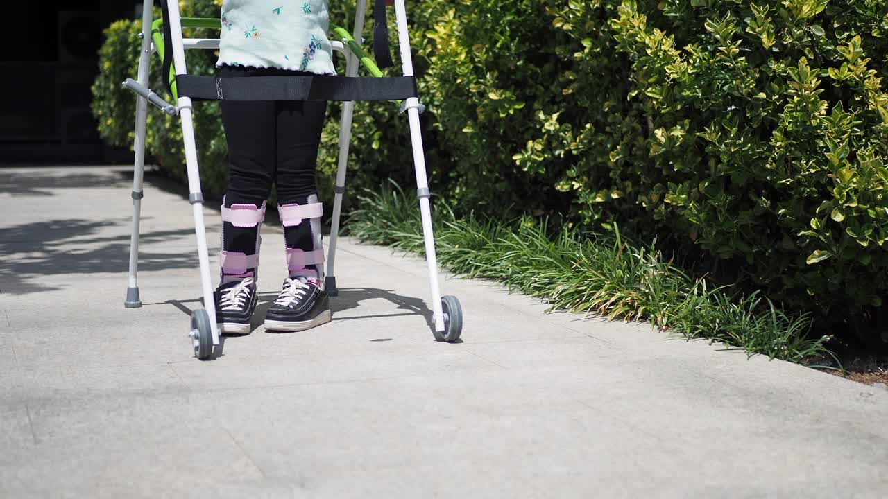 En ung pige med gips på benet, der går med en rollator