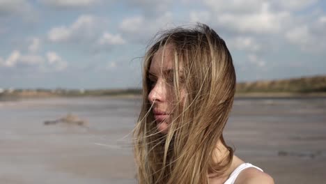 portrait of a long haired thoughtful woman standing with lake on the background