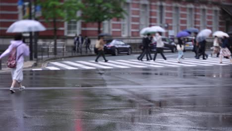 walking people on the street in marunouchi tokyo rainy day