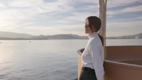 Shot-of-a-woman-standing-by-the-sea-and-looking-at-it-during-golden-hour