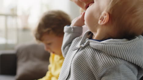mother spending time at home with baby and elder son