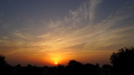 rayos de sol rojizos con puesta de sol. primer plano horizontal del sol que se esconde en el cielo nublado. concepto de naturaleza con vista de amanecer o puesta del sol.