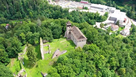 antiguo castillo pequeño en una pequeña colina rodeada de árboles hermoso lugar natural - disparo de drones