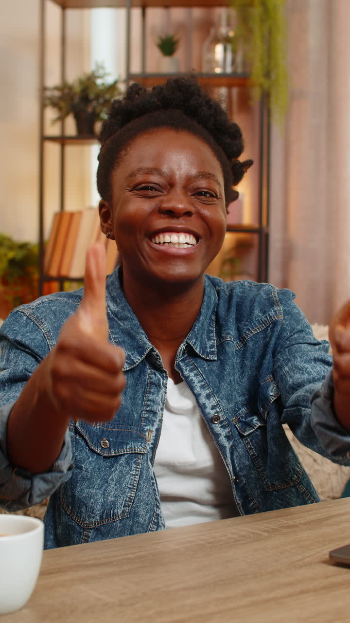 African american woman celebrates success after finishing laptop work happy victory gesture at home