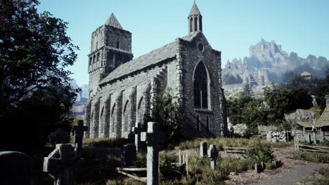 stone church in a graveyard, with a medieval castle in the background