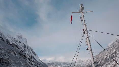 imágenes de un ferry en el fiordo de geiranger, noruega, durante el invierno, capturando el fiordo, las montañas cubiertas de nieve y un cielo brillante