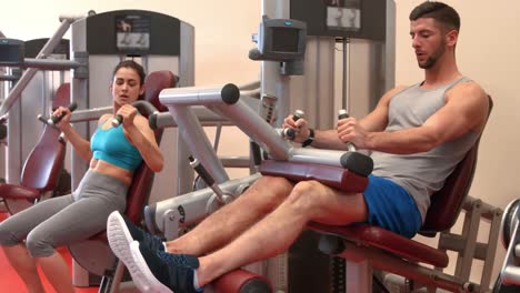 pareja en forma usando máquinas de pesas