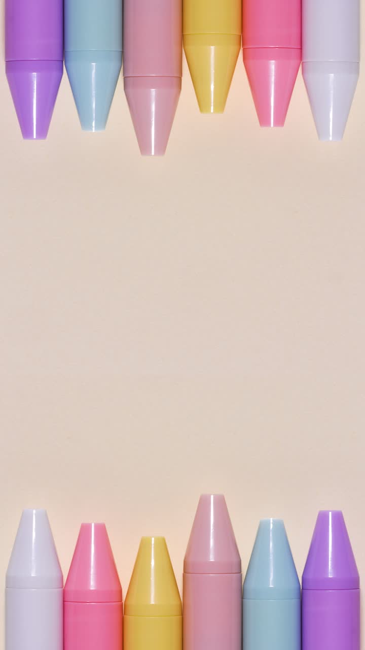 Portrait stop-motion loop of pastel pens forming a top-and-bottom border on beige, large central copy space