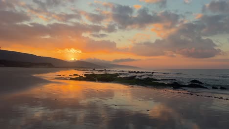 Waves-rolling-into-rocks-on-a-peaceful-beach-during-a-perfect-sunset