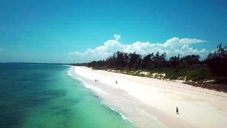 people at the beautiful tropical beach with white sandy shore in kenya coast, africa. aerial drone shot